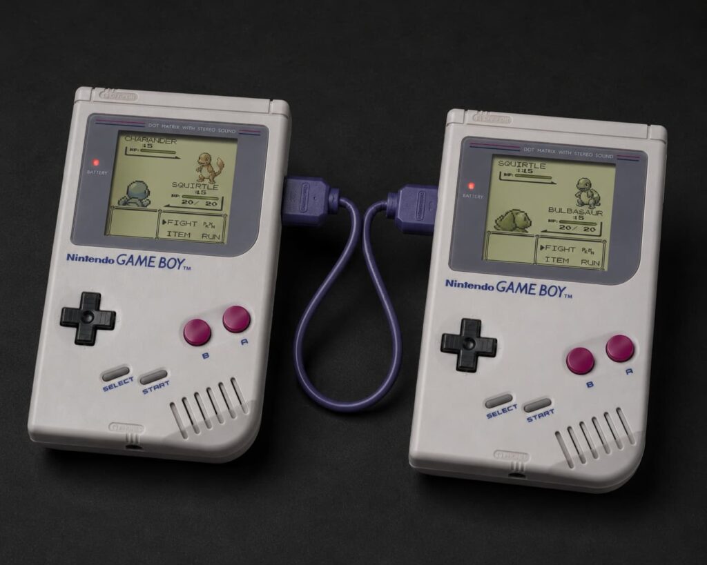 Two Game Boys connected by link cable playing Pokémon — the social gaming revolution